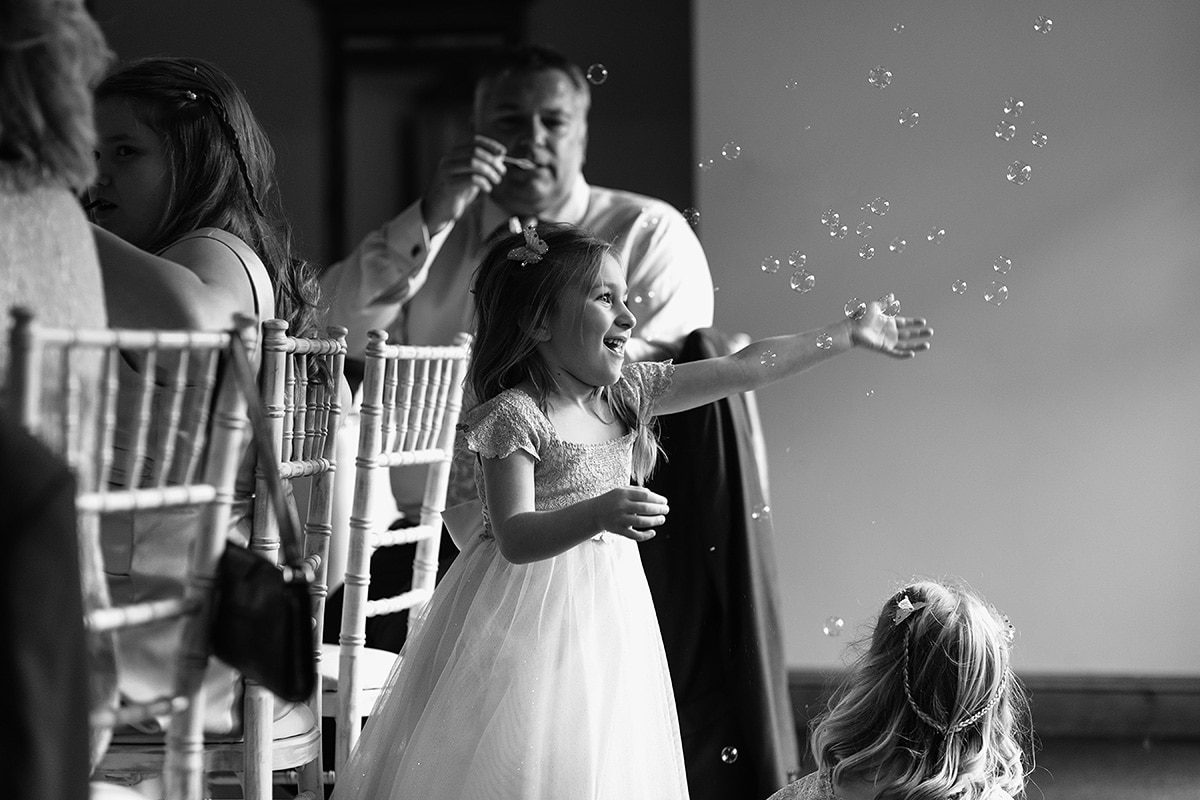 a flower girl catches bubbles