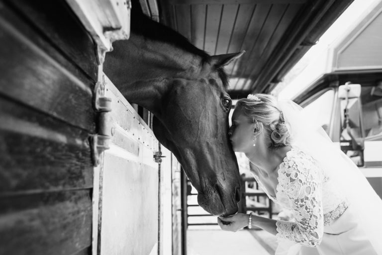 a bride with her horse on her wedding dat