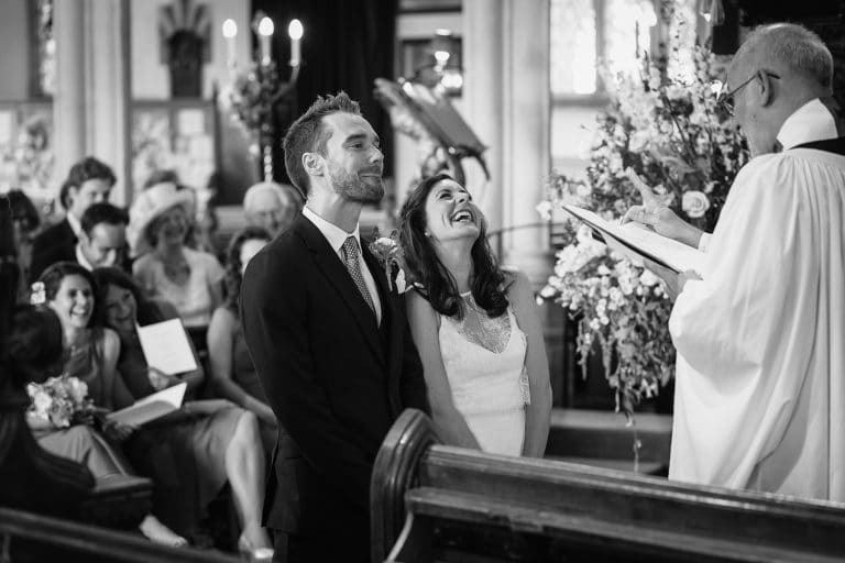 bride and groom laugh in southwold church