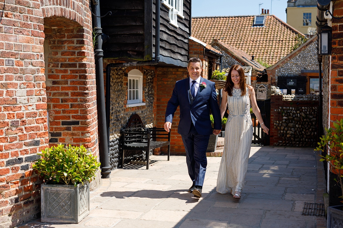 bride and groom walk in together to their cley mill wedding