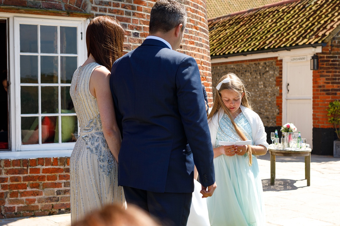 a young girl reads during the ceremony