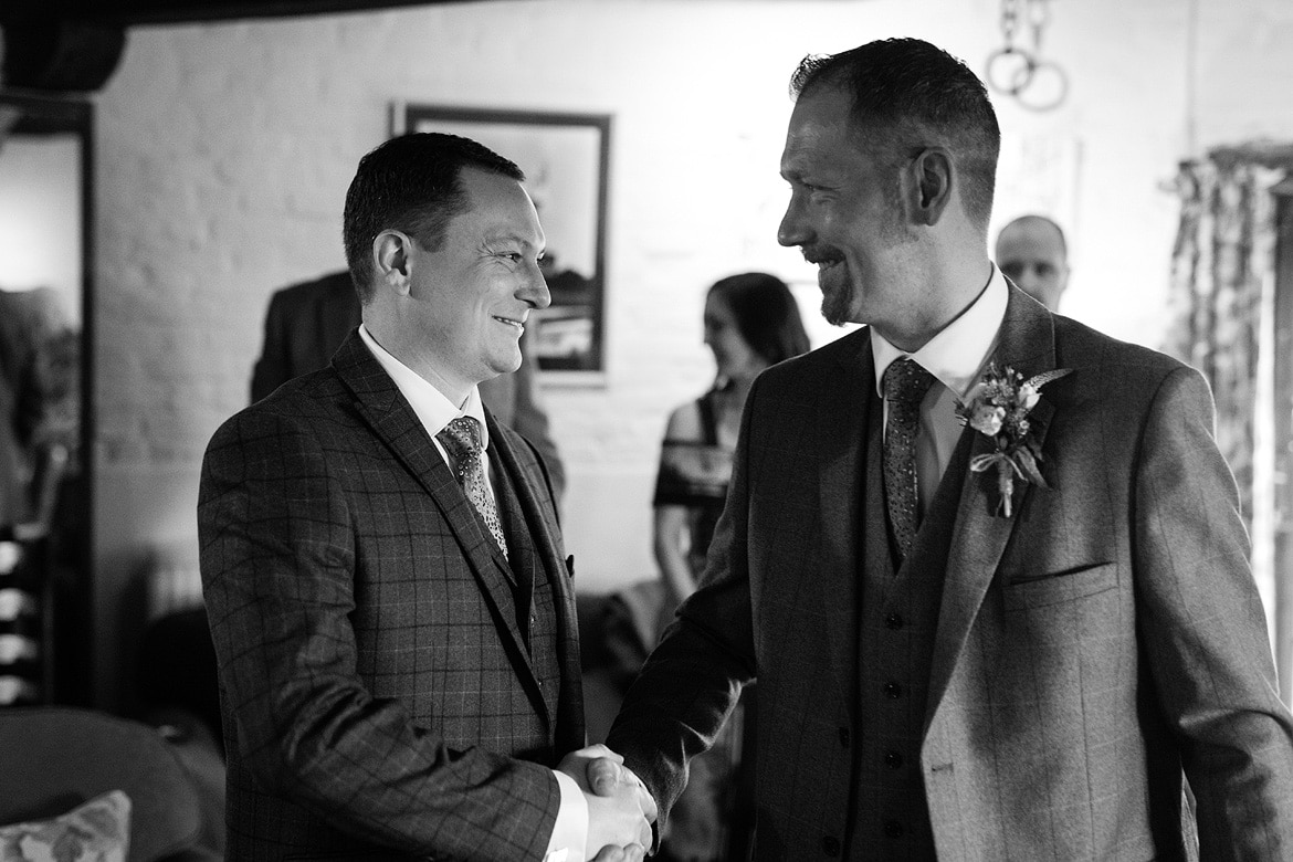 the groom shakes hands with the best man