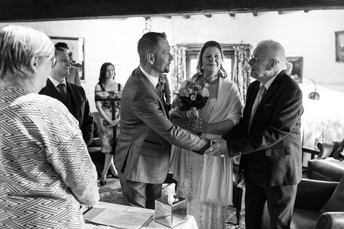 the groom shakes hands with the father of the bride