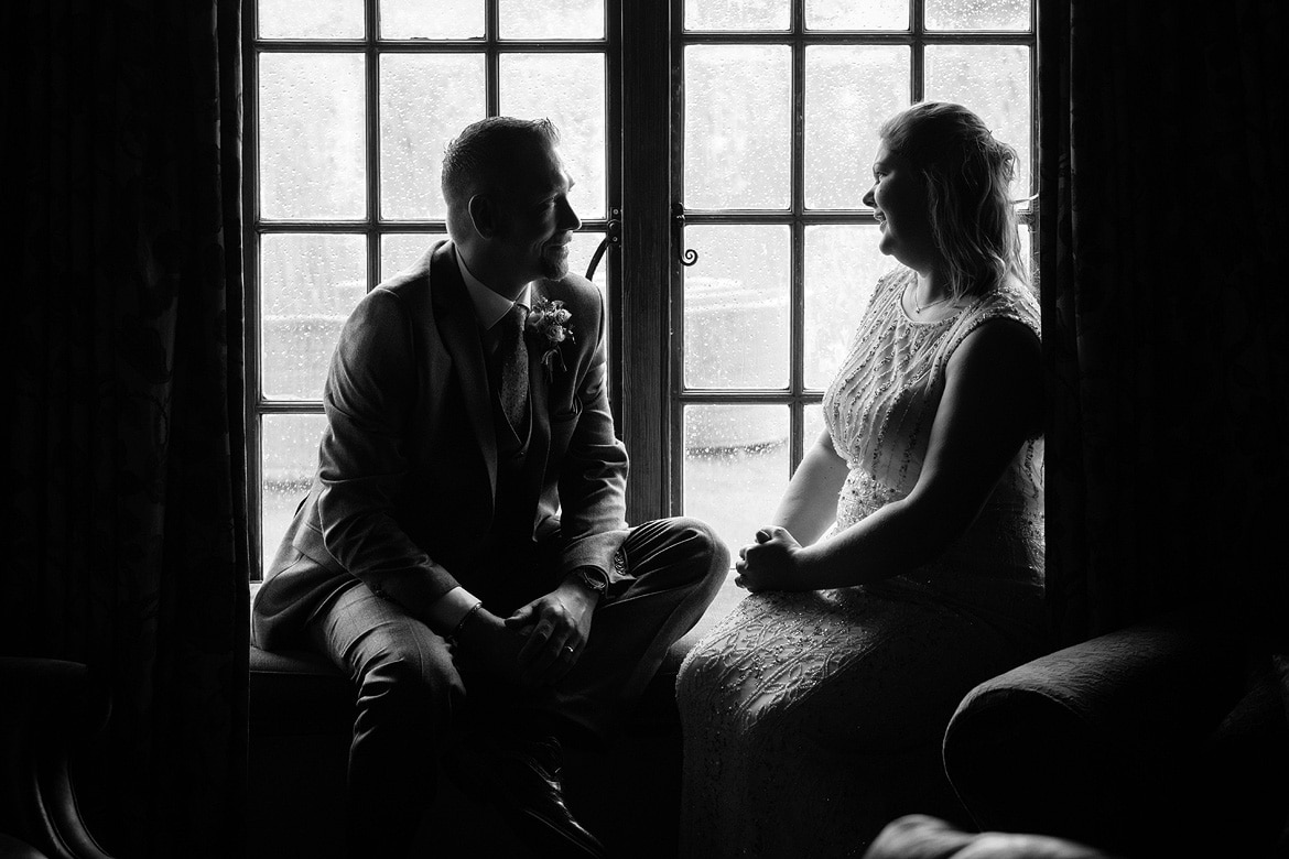 bride and groom in the window at their cley mill wedding