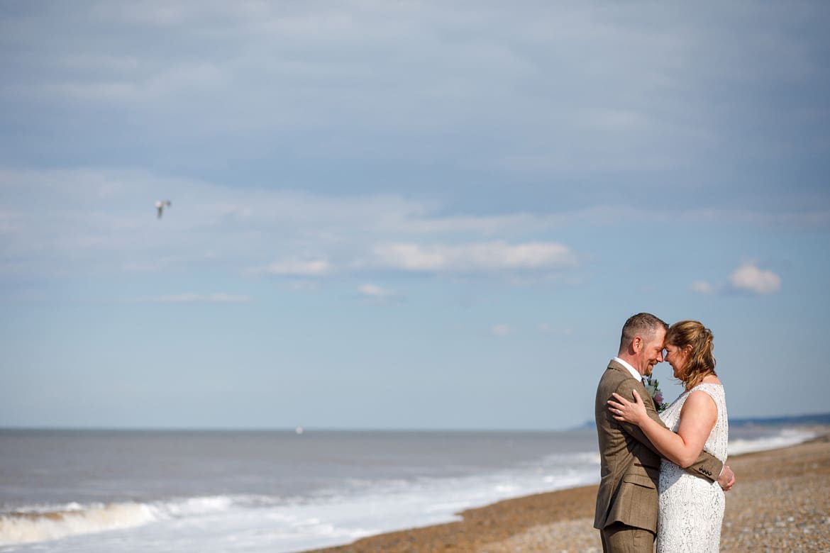 bride and groom on the beach after their cley mill wedding