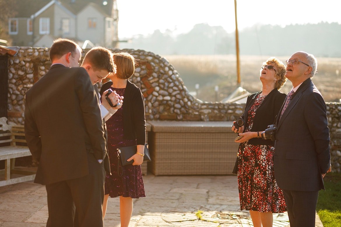 wedding guests look up at cley windmill