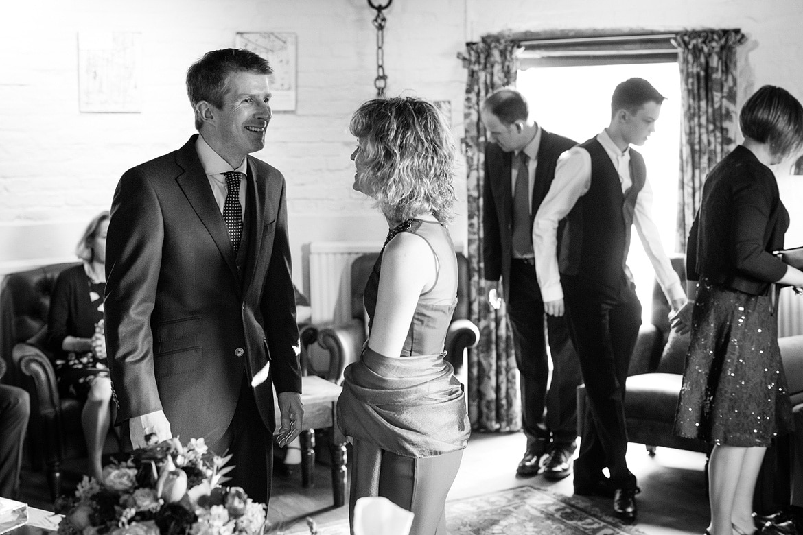 bride and groom laugh as their guests enter the ceremony