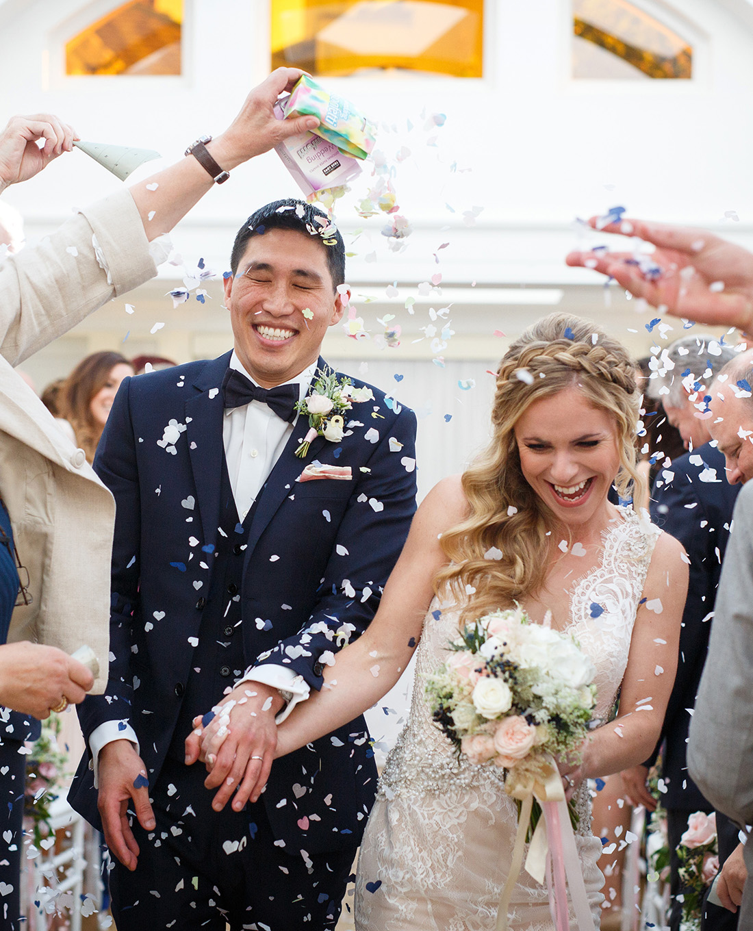 bride and groom running through confetti