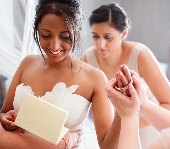 bride getting dressed with her bridesmaids