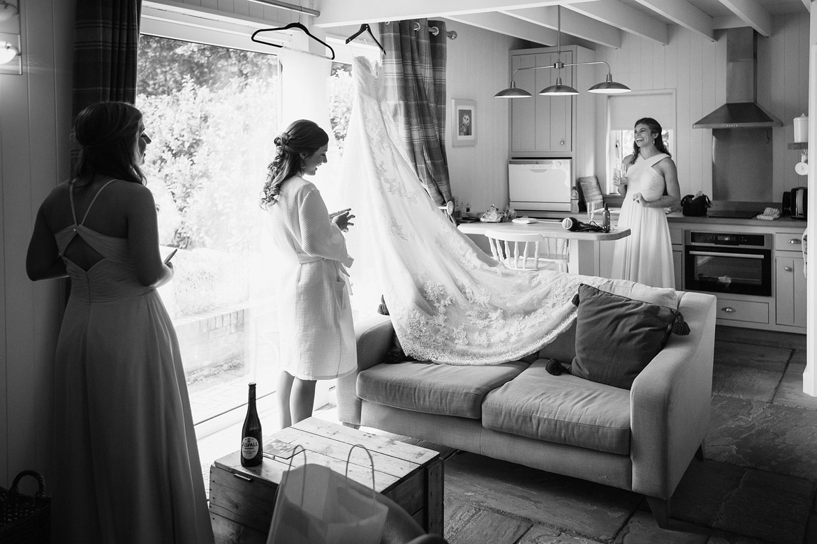 the bride takes down her dress from the window