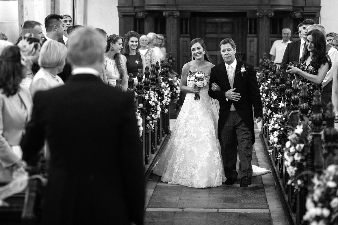 the bride and her father walk down the aisle
