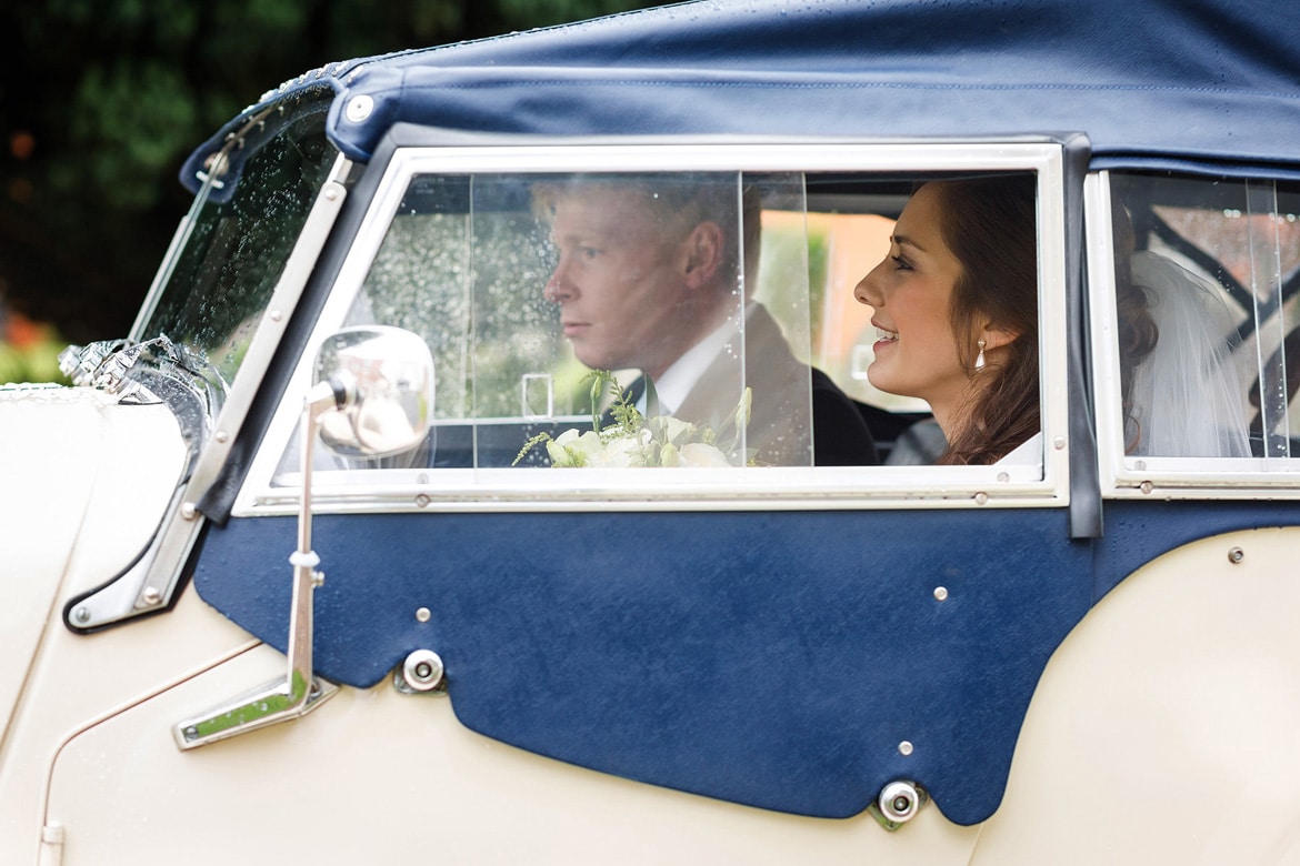 bride and groom in their vintage wedding car