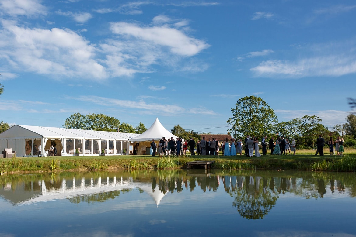 a marquee wedding in suffolk reflected in the pond