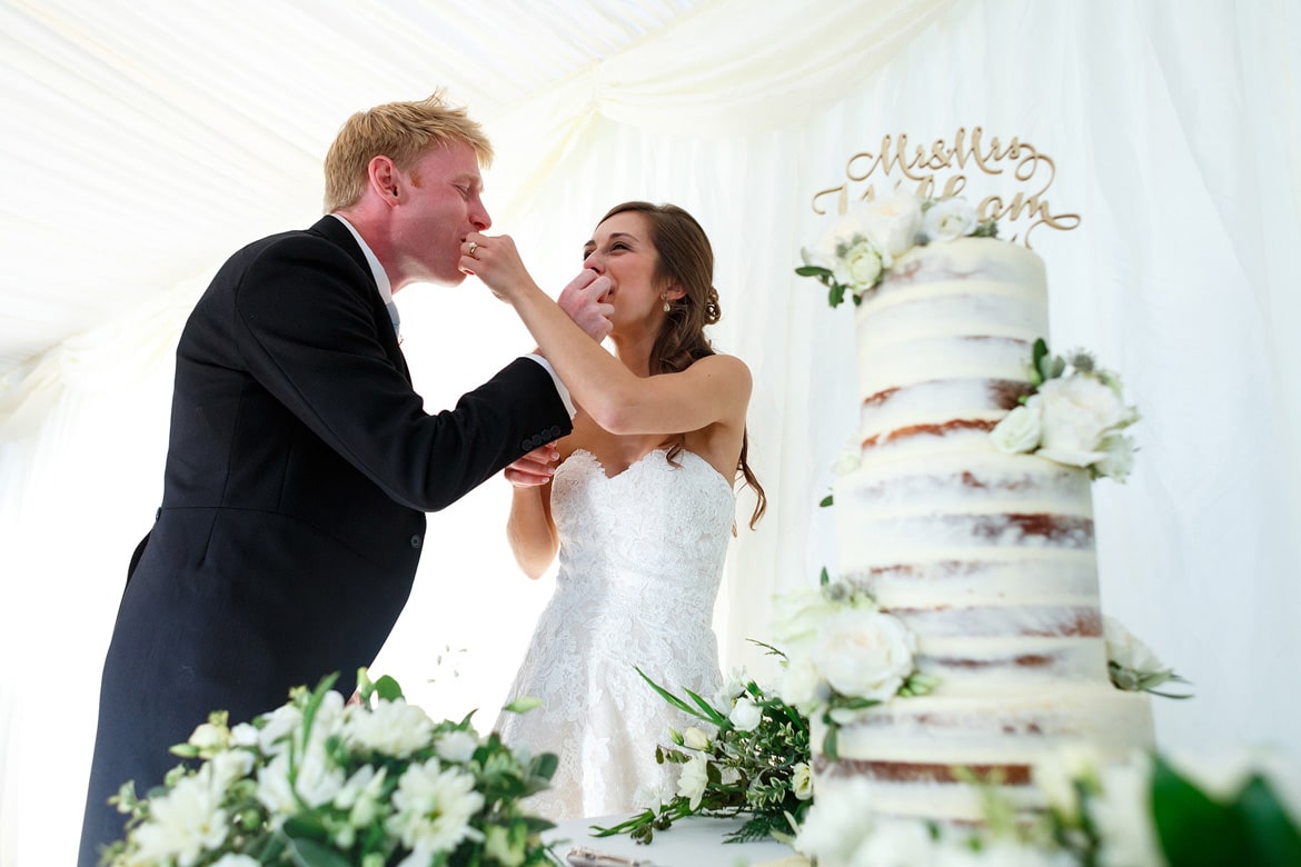 bride and groom exchange bites of their wedding cake