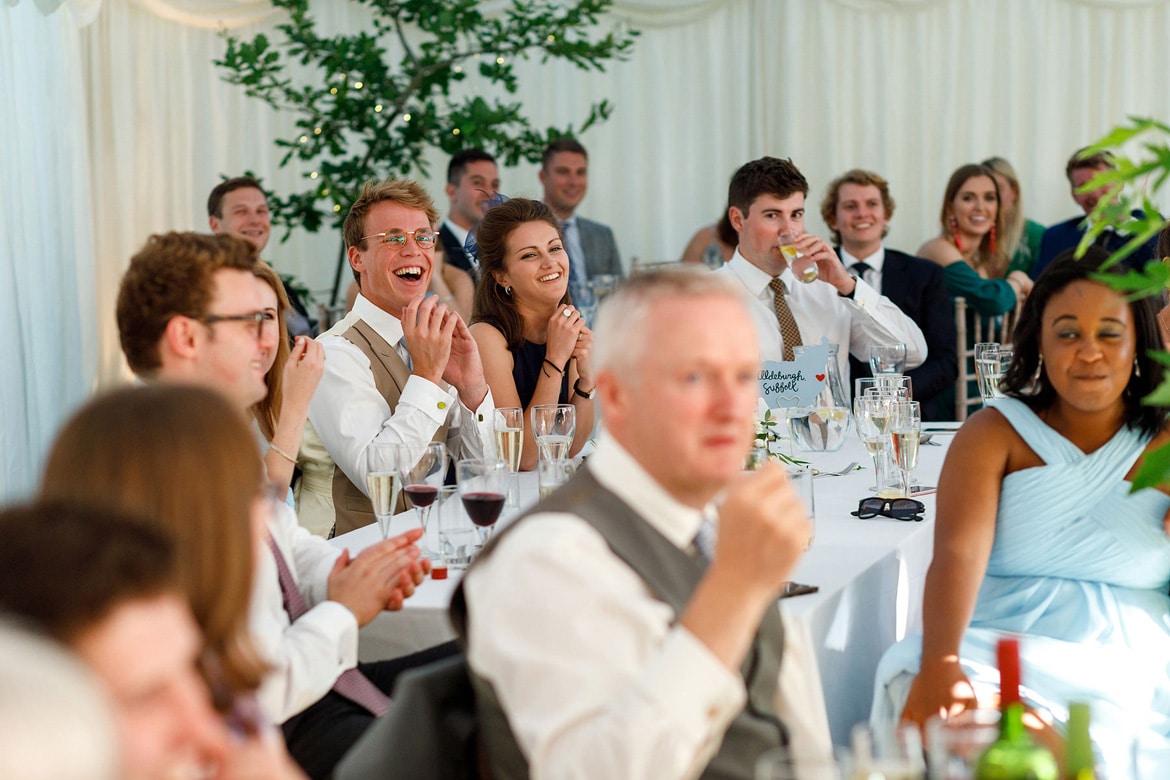 guests laugh at the grooms speech