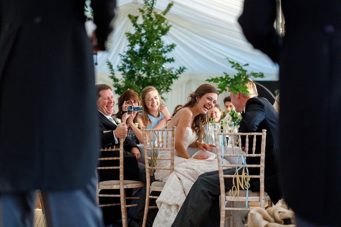 bride and groom laugh during the best mens speech