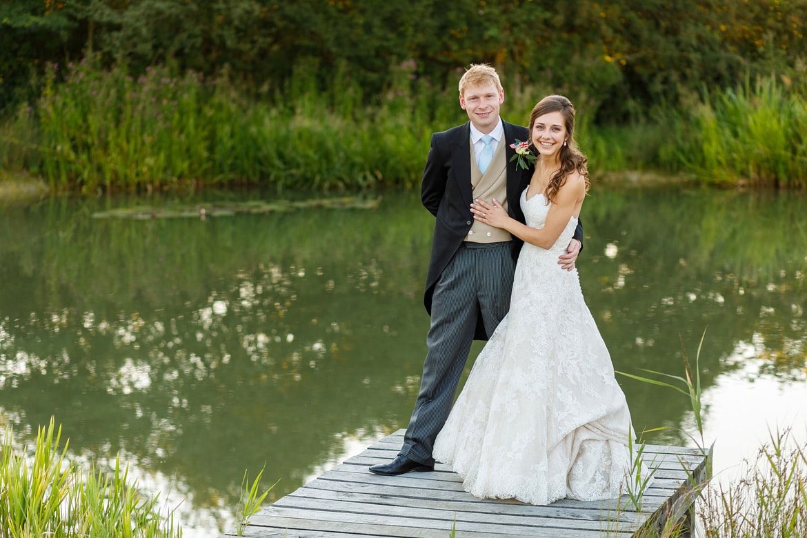 bride and groom pose on the jetty