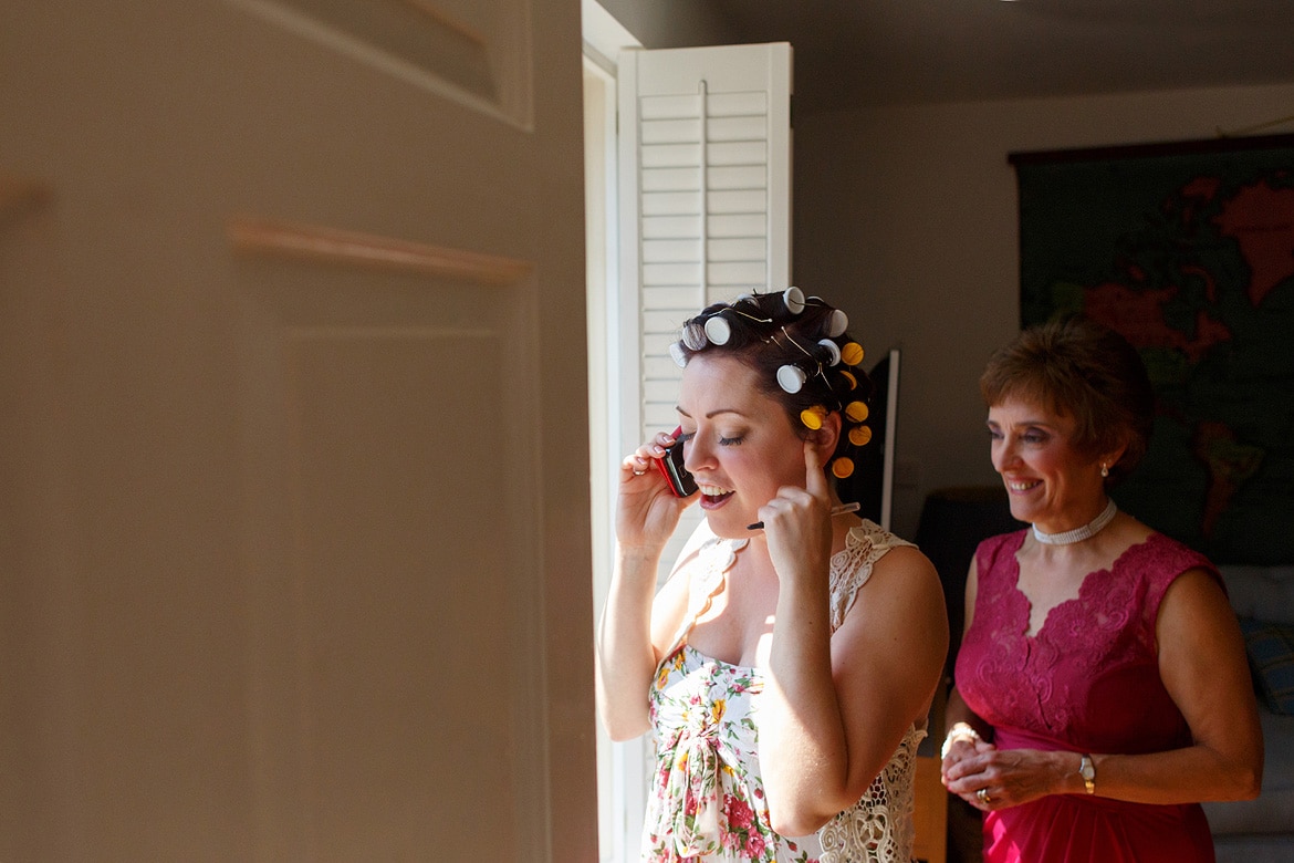 the bride speaks on the phone with her mother