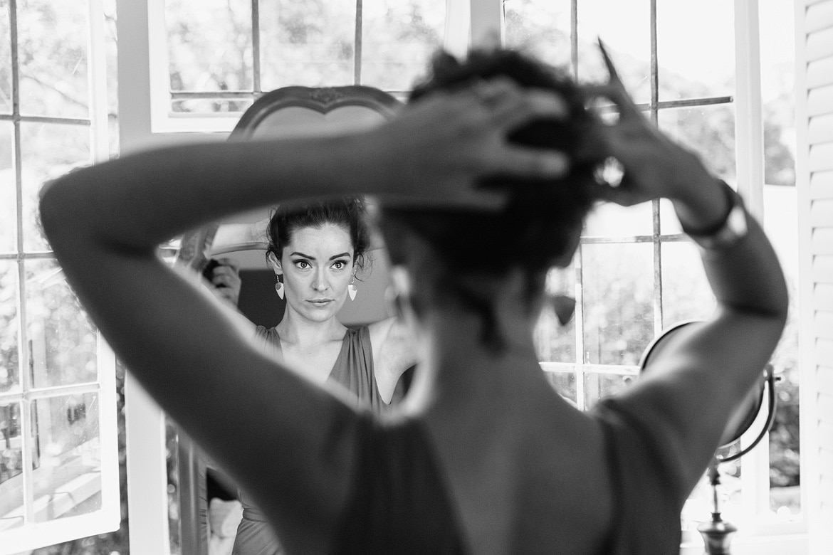 a bridesmaid fixes her hair