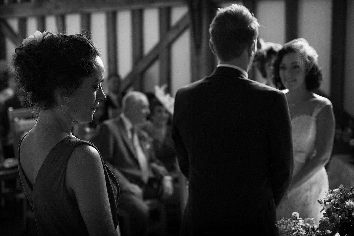 the bridesmaid backlit during the ceremony