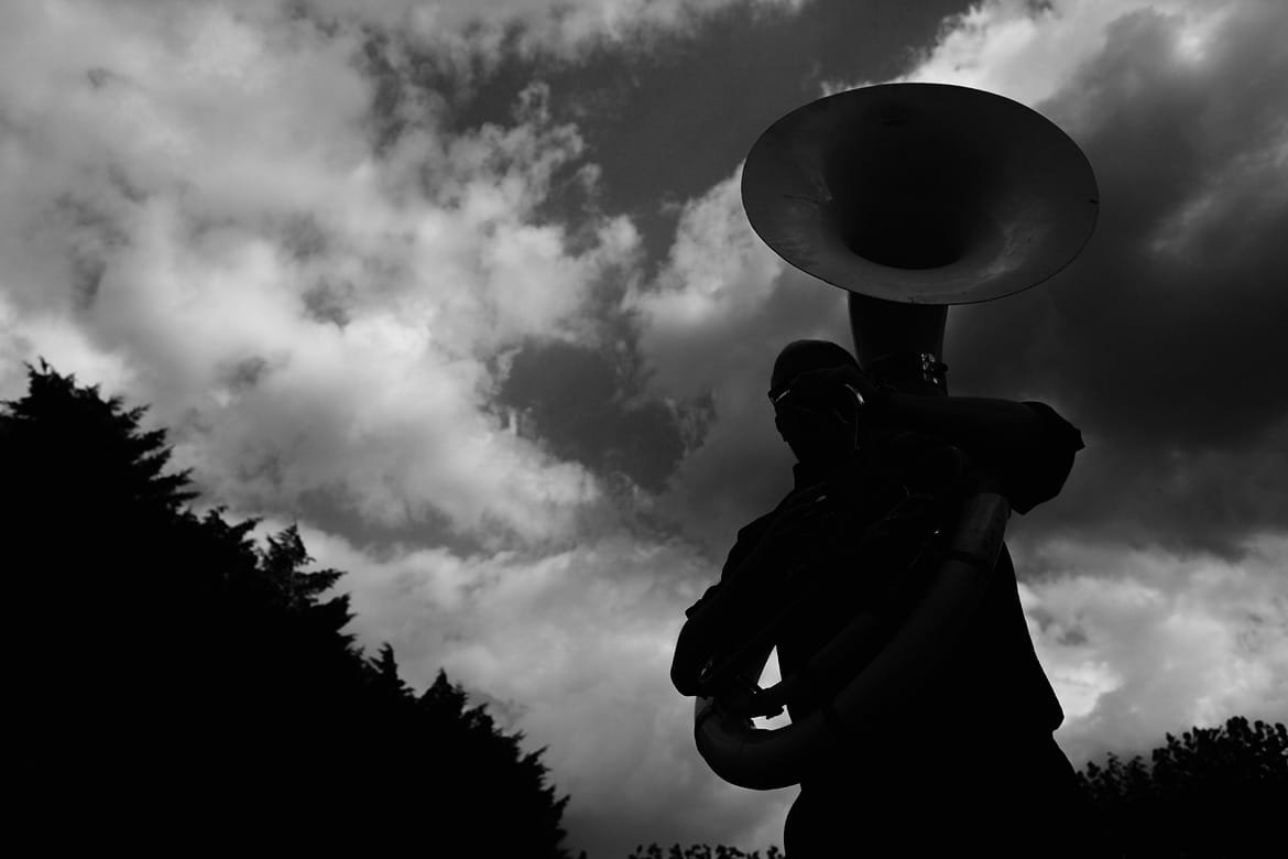 a tuba player silhouetted