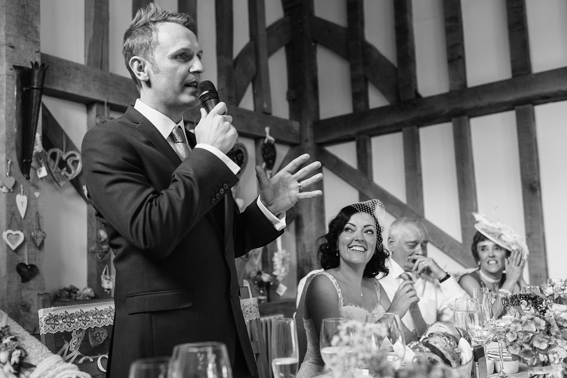 the groom speaks as the bride looks on