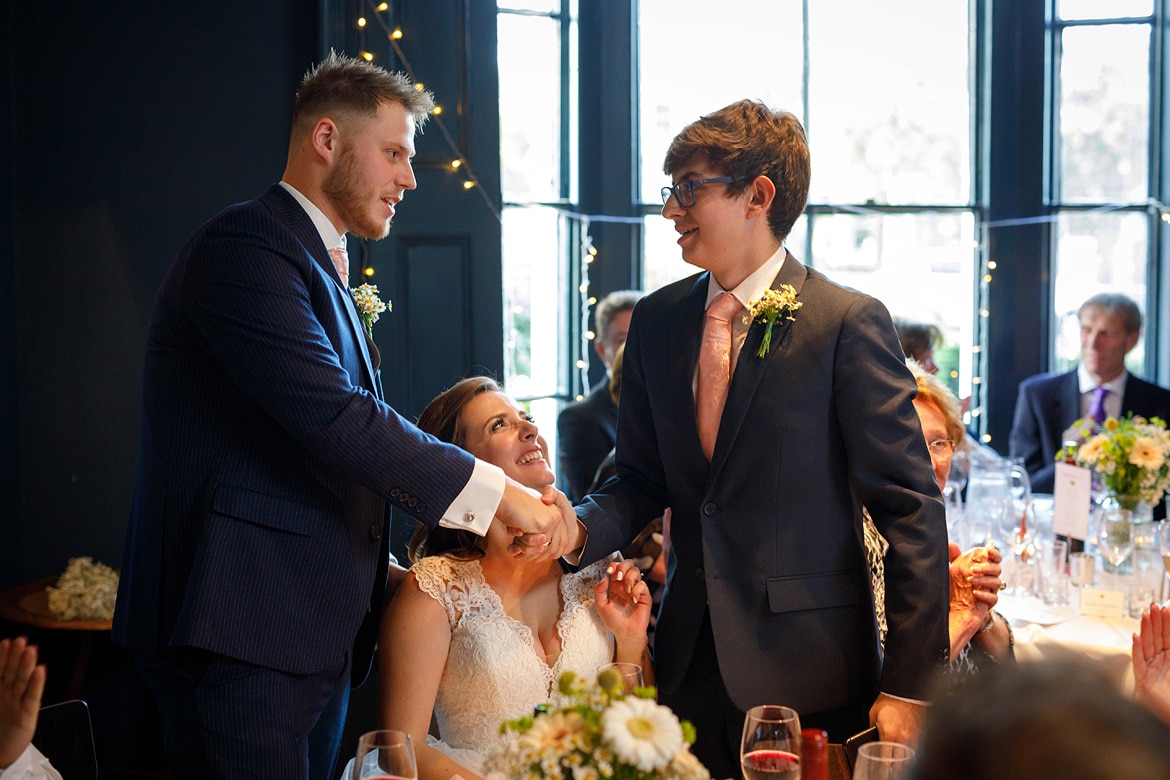 the groom shakes hands with the brides brother