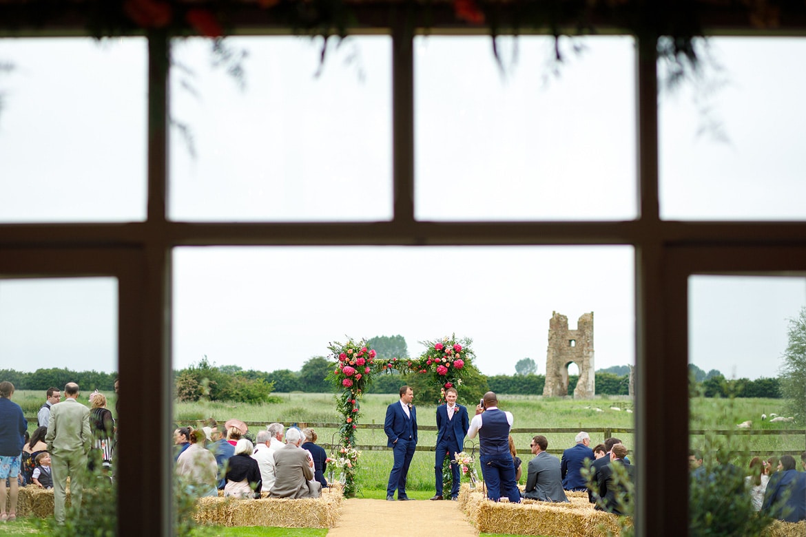 groom and best man wait outside godwick barn