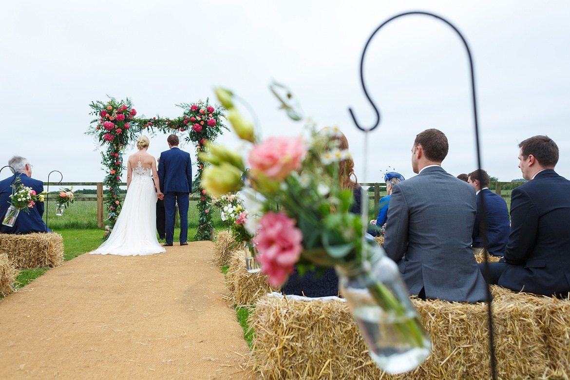 a view from the back of an outdoor wedding ceremony at godwick barn