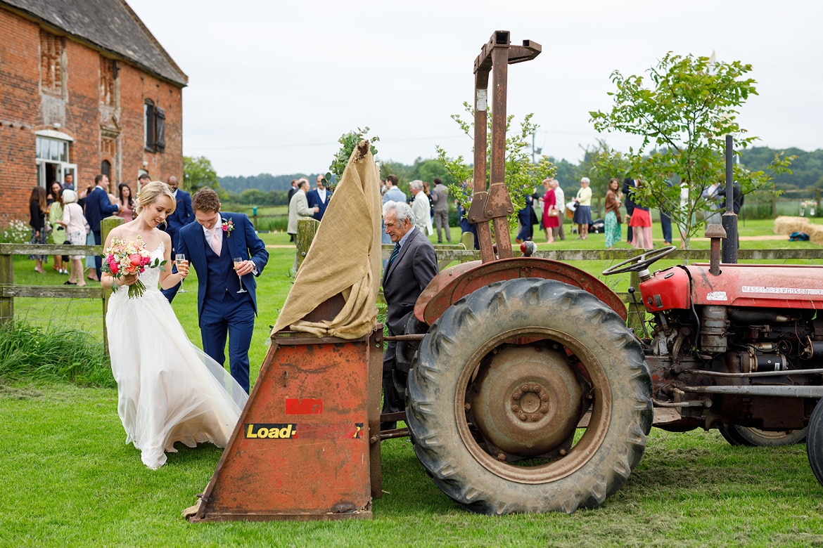 bride and groom get into the godwick tractor