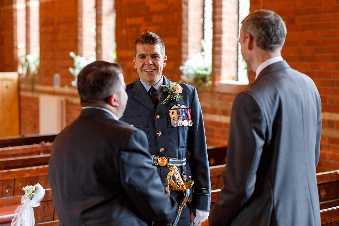 the groom talks to guests inside the chapel
