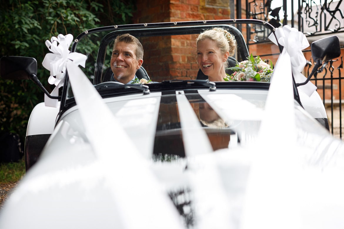 bride and groom in their robin hood wedding car