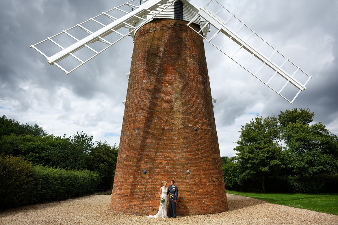 bride and groom pose in fron of dereham windmill