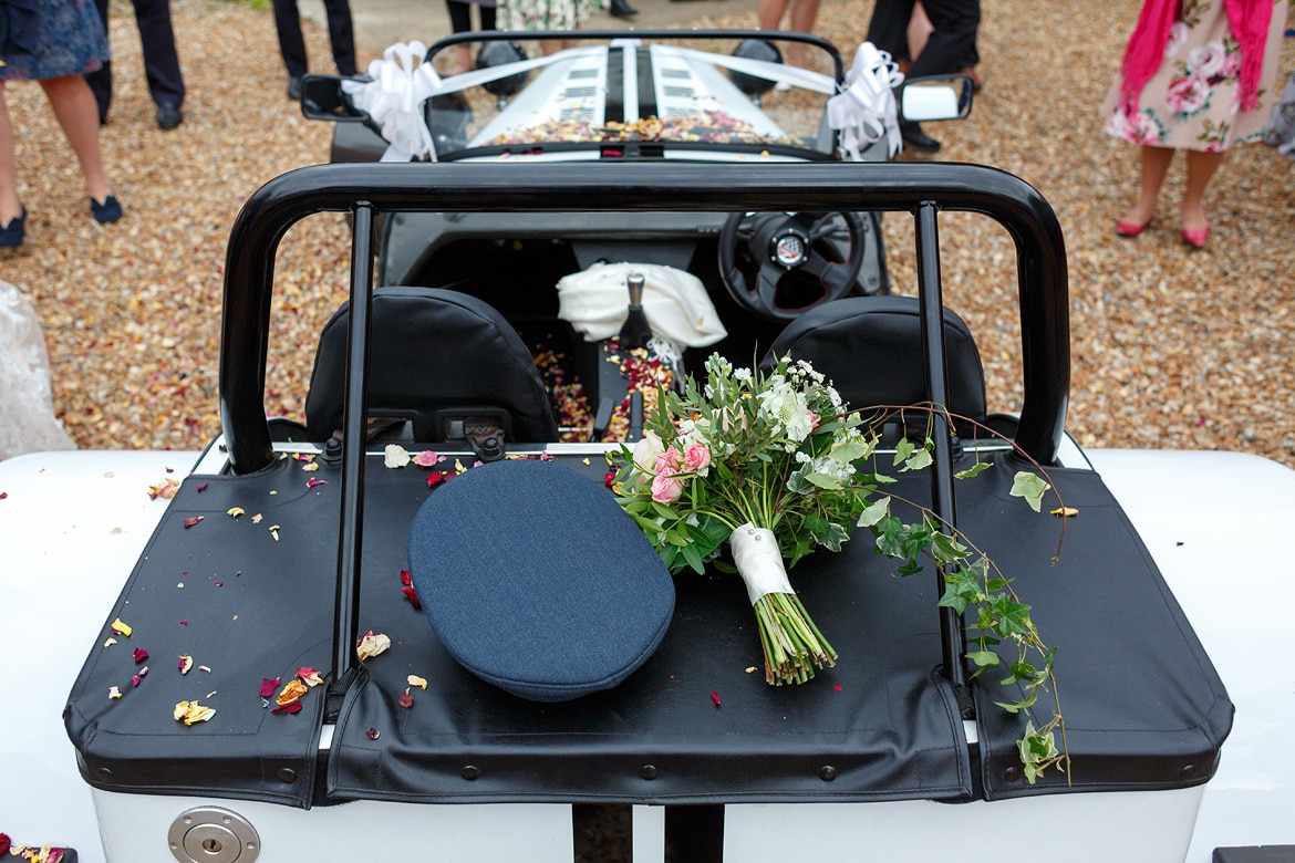 flowers and the grooms hat on the car