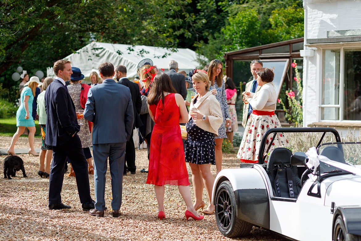 wedding guests chat in the driveway