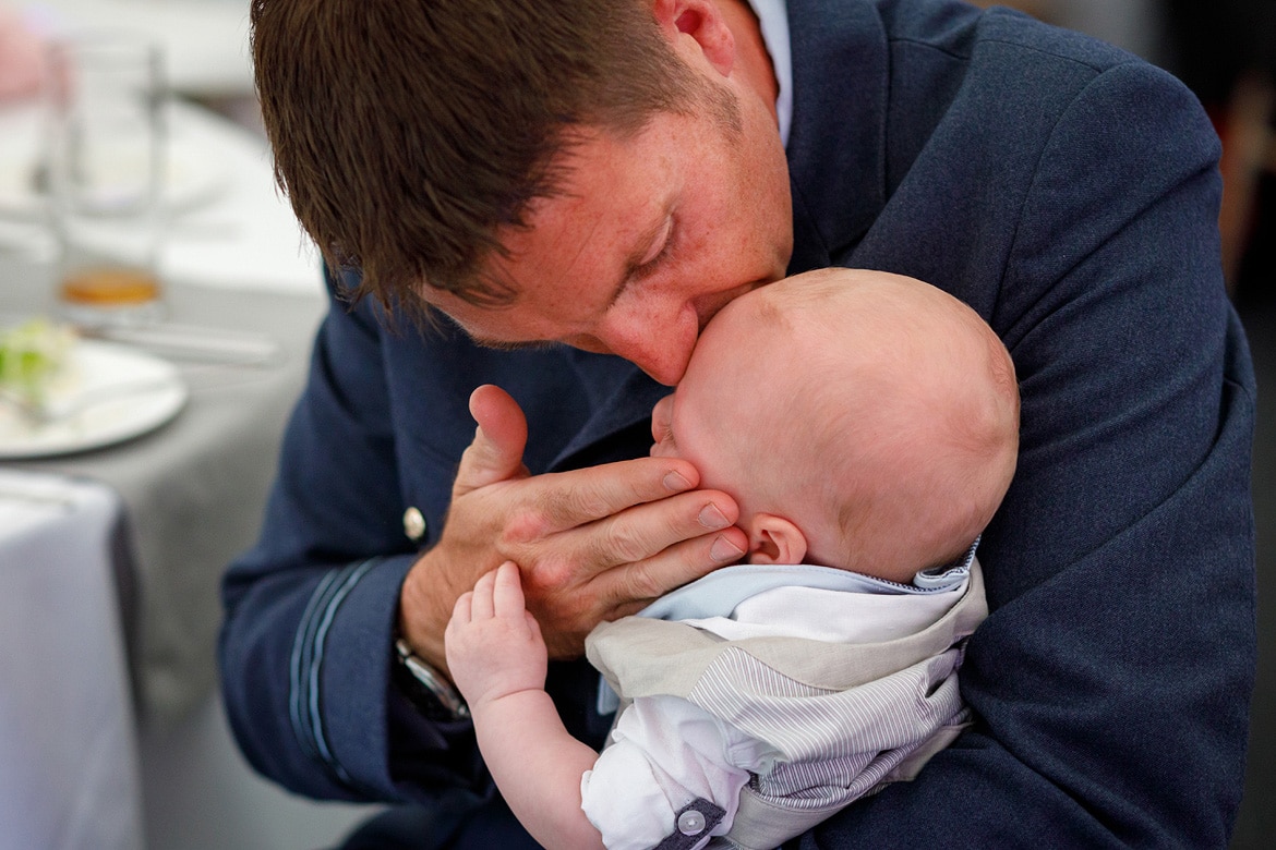 a guest kisses his baby