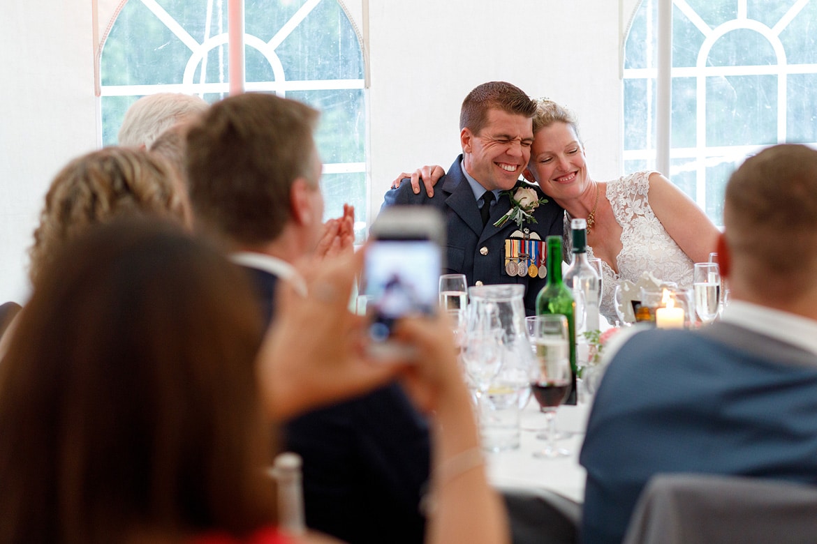 bride and groom embrace at the top table