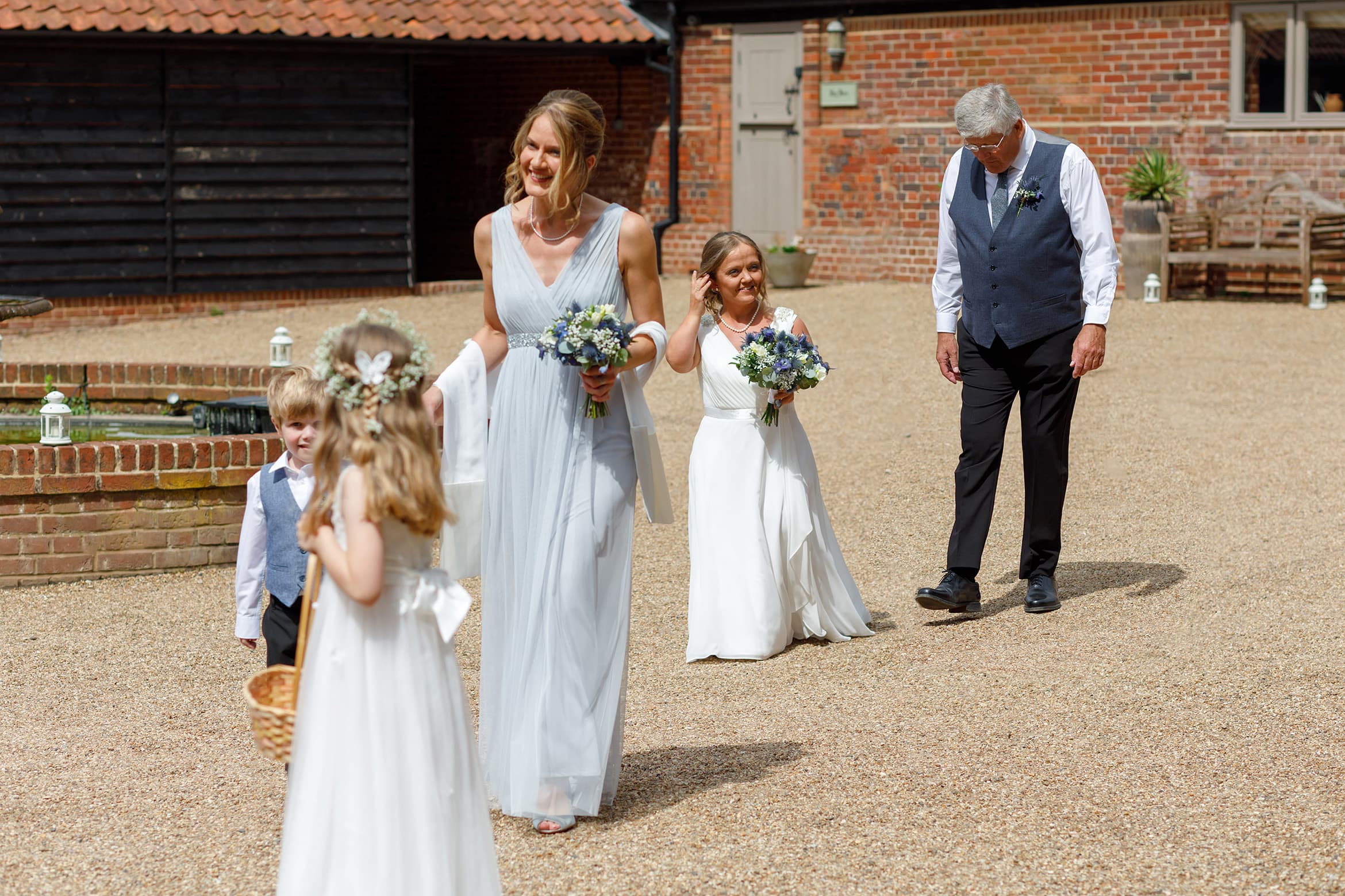 the bride walks across the courtyard at hautbois hall