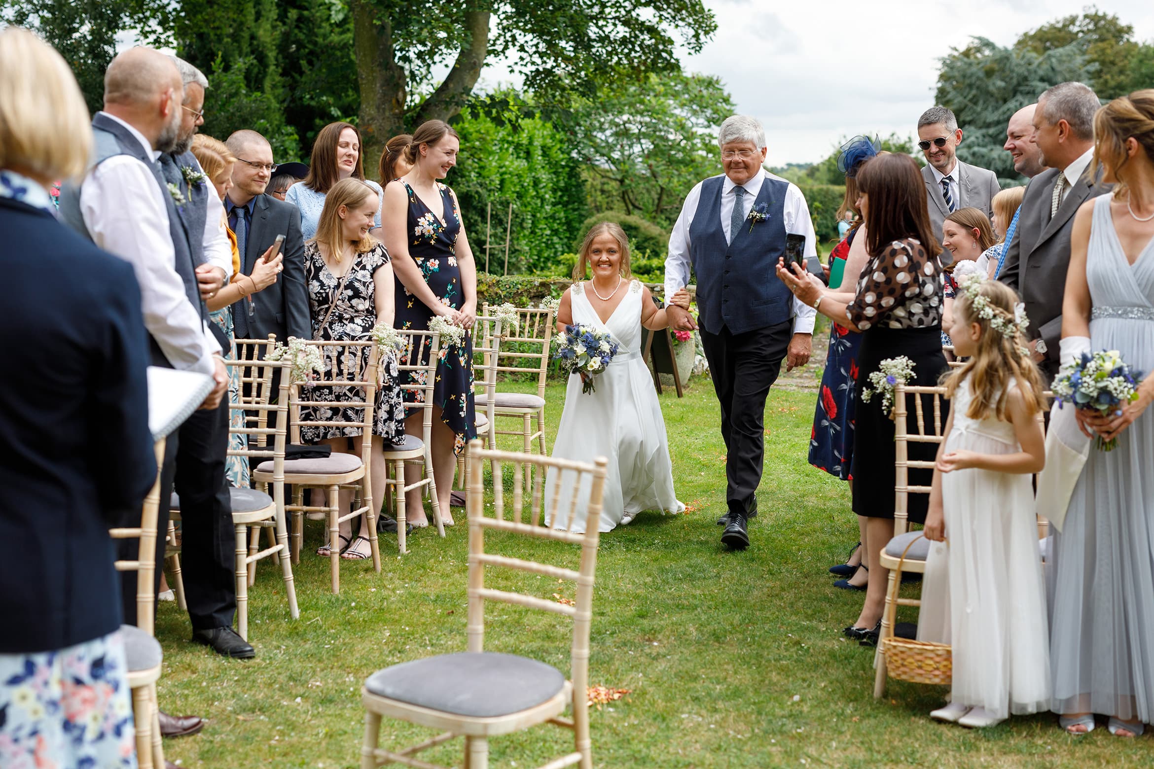 the bride and her father walk down the aisle