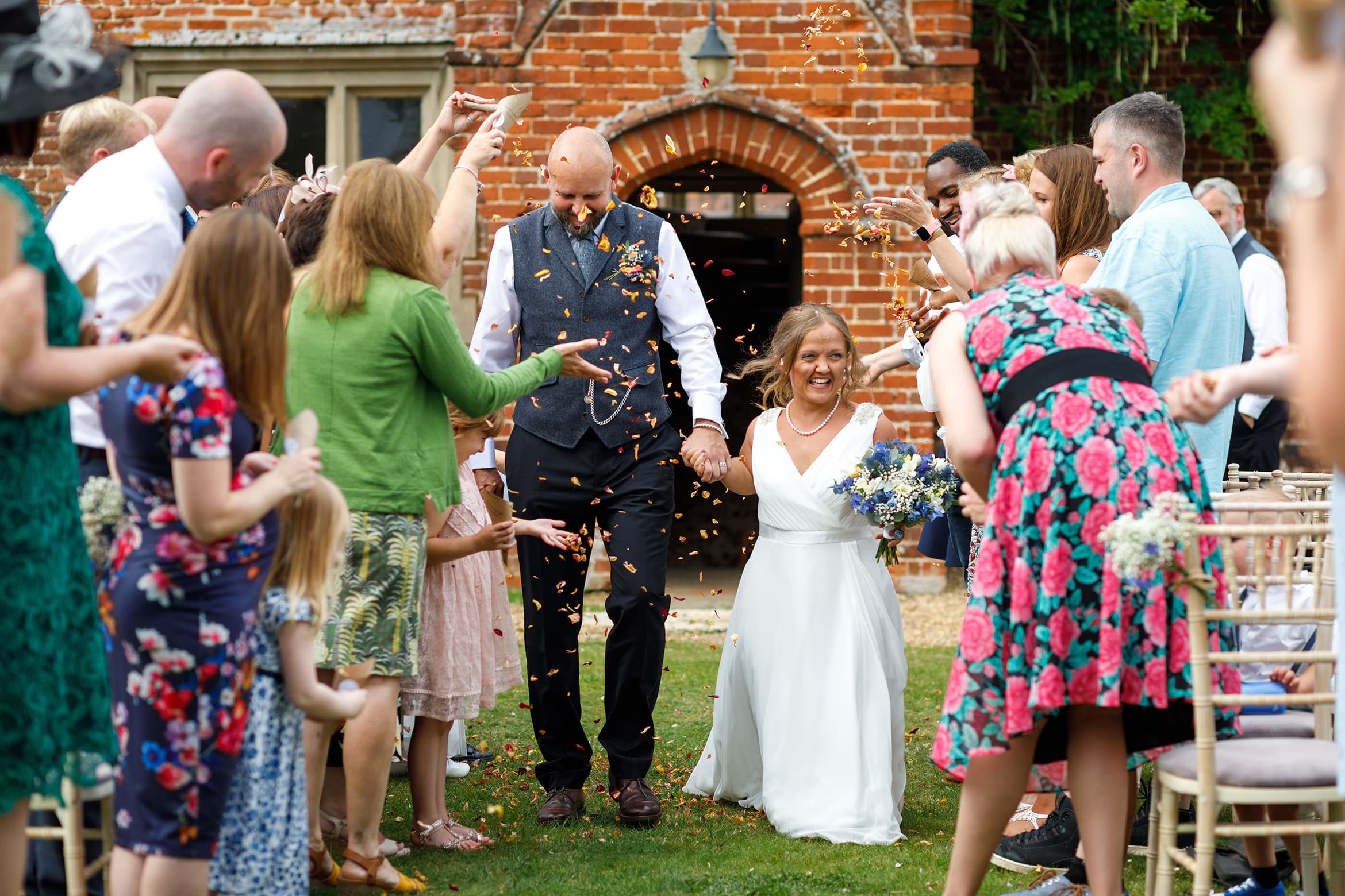 bride and groom walk through the confetti