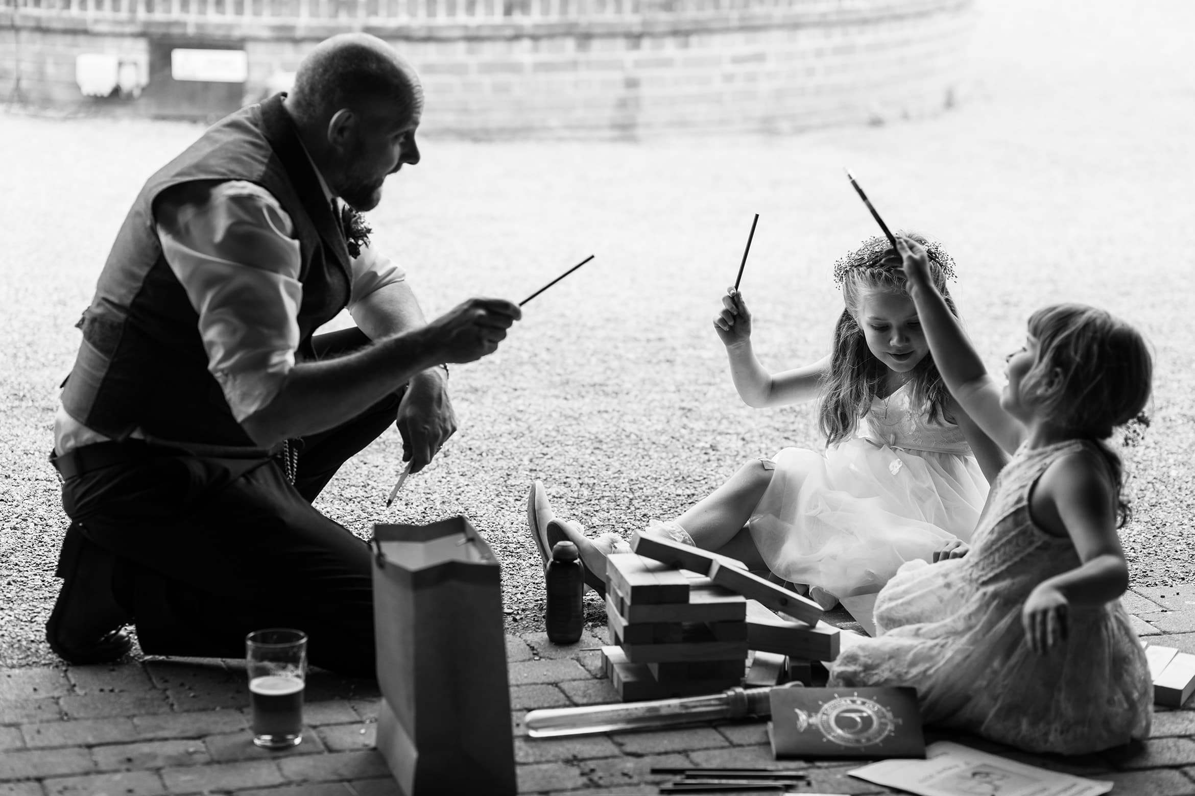 the groom casts spells with the flowergirl