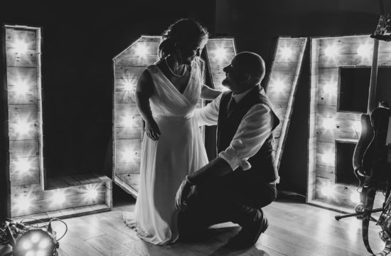 bride and groom in front of a love sign at hautbois hall wedding