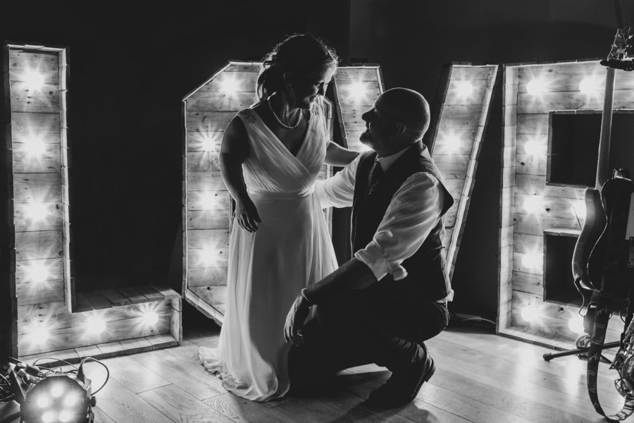 bride and groom in front of a love sign at hautbois hall wedding