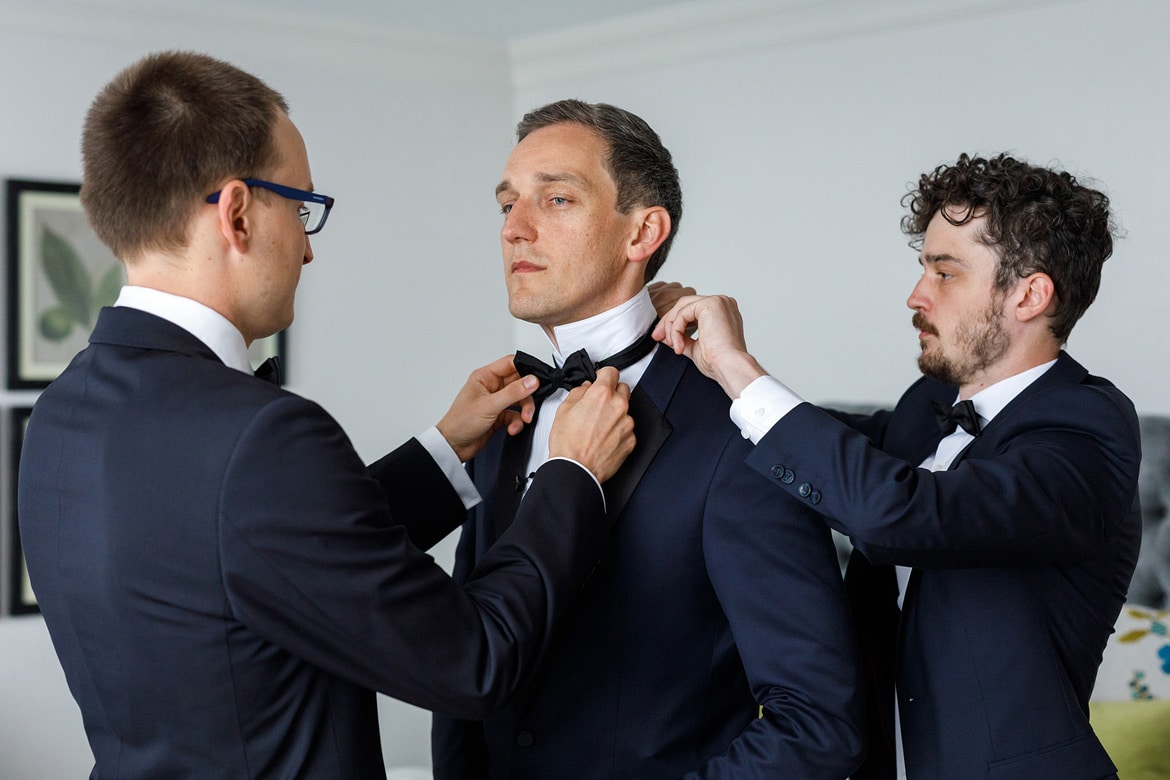 the groomsmen help the groom get ready