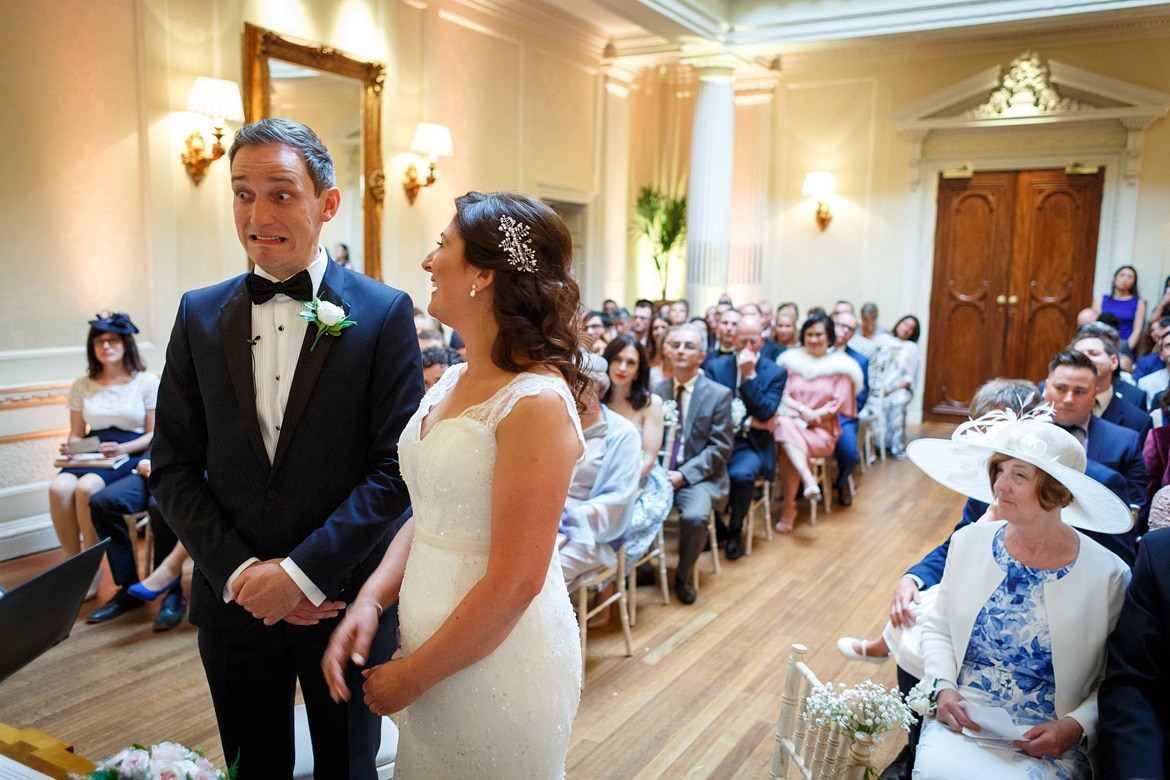 the groom pulls a face during his hedsor house wedding ceremony