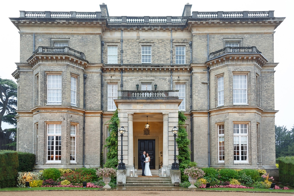 bride and groom pose outside hedsor house