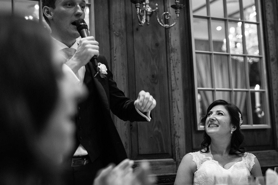 the bride looks at the groom during his speech