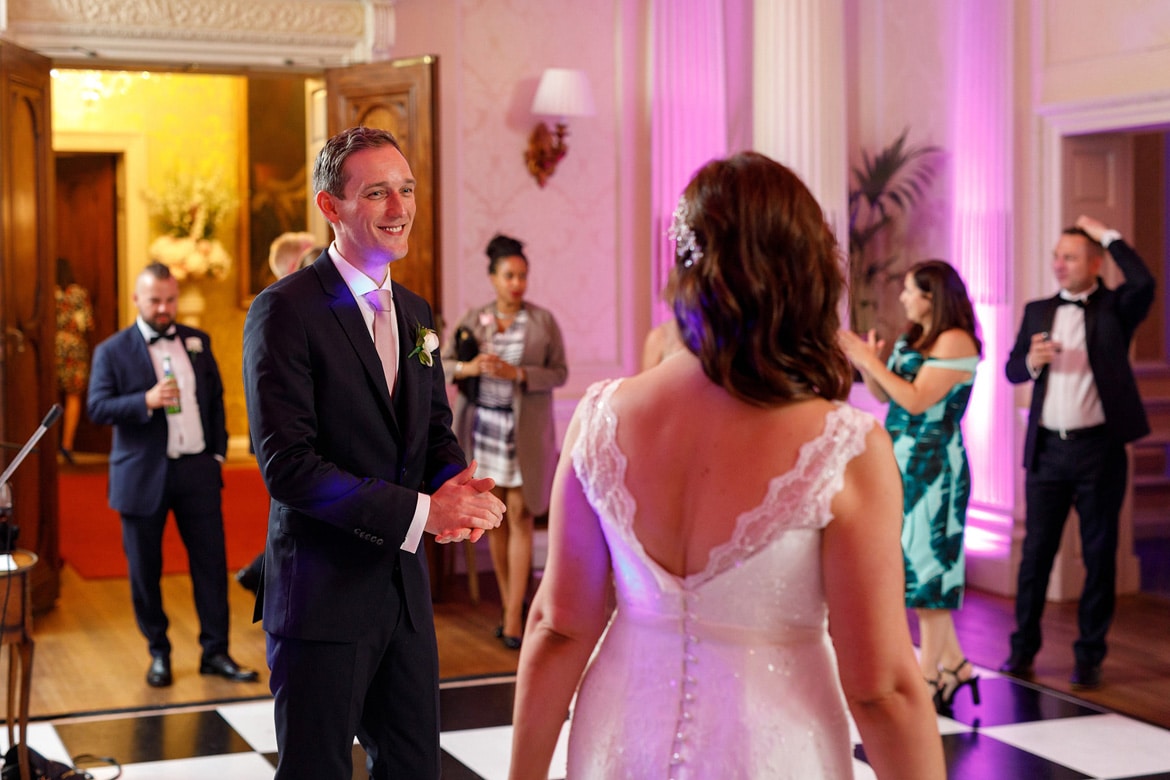 the groom looks at the bride before their first dance