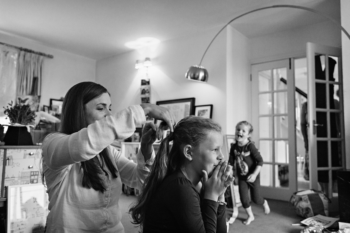 flowergirls running while the bride tries to do their hair