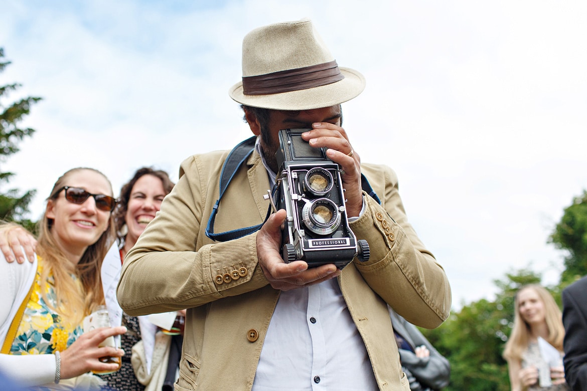 a wedding guest takes a photo on a vintage camera